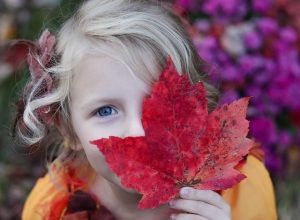 menina com uma folha de outono
